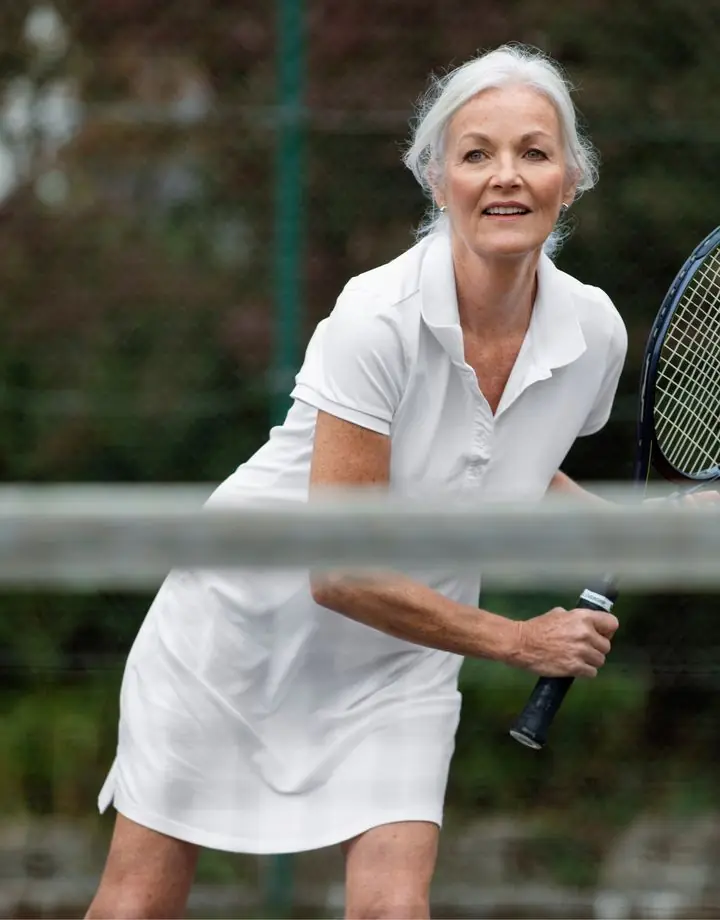 Mulher de cabelos brancos jogando tênis