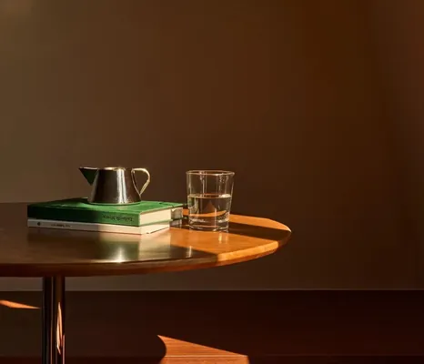 Wooden table with a cup and books in a dimly lit room